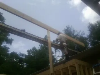 Carpenter setting a ridge beam over a new addition frame — Ice Dam Removal by Roofing Brothers in Rushsylvania