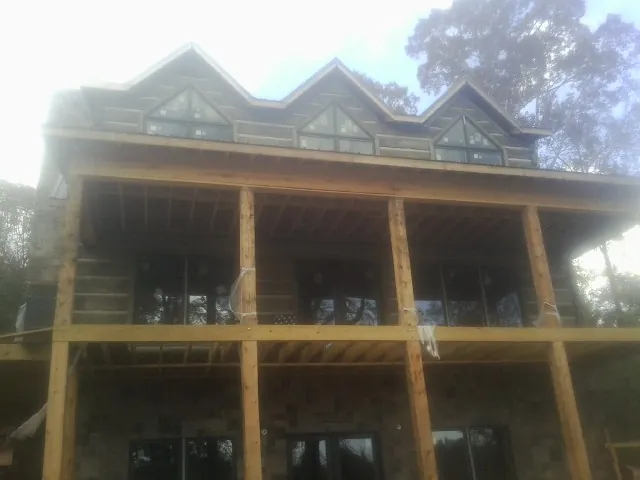 Dormers and porch framing on a large log home under construction — Roof Coating work by our crew in Rushsylvania